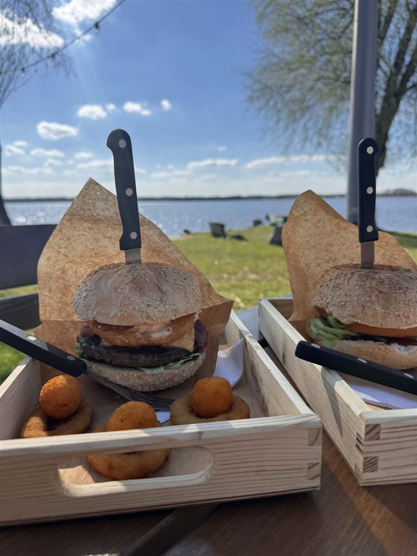 Burgery na drewnianej desce z widokiem na jezioro